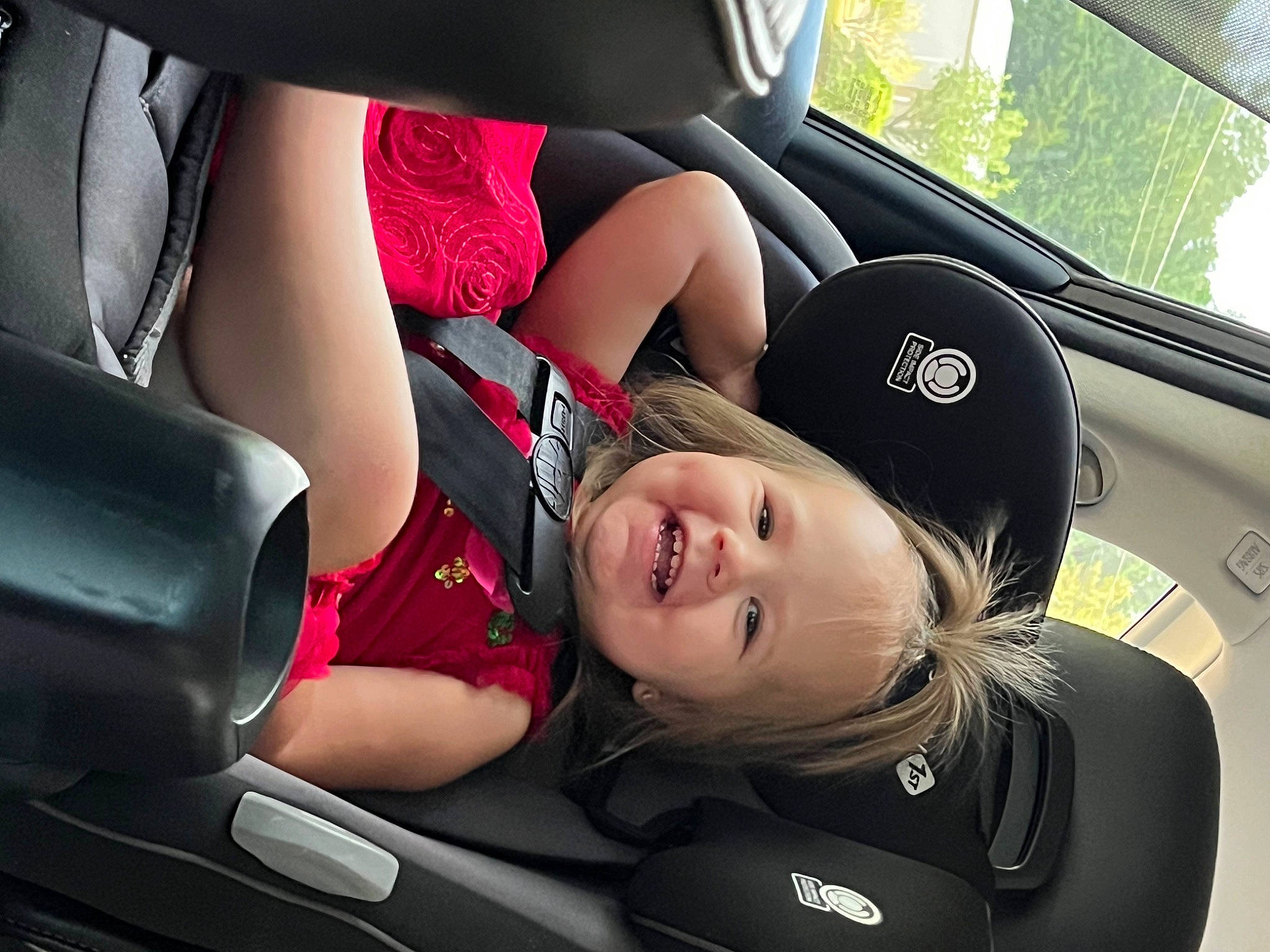 Adley is registered to the contest to win money with this photo: auto_part, automotive_design, automotive_exterior, automotive_tire, car, car_seat, car_seat_cover, comfort, face, flash_photography, head_restraint, joy, motor_vehicle, person, personal_luxury_car, seat_belt, smile, steering_part, steering_wheel, toddler