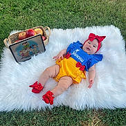 Valeryn is registered to the contest to win money with this photo: baby, grass, outdoor, basket, apples, tablet, cartoon, princess_outfit, headband, red_bow, socks, fluffy_rug, smile, child, cute, playing, colorful_clothing, portrait, nature, relaxing