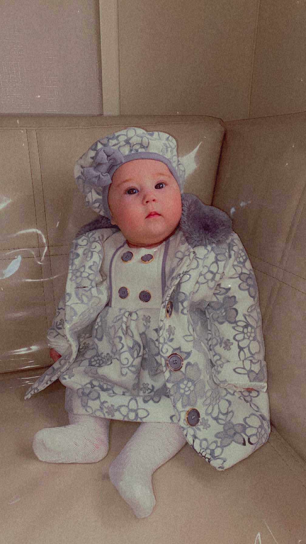 Swan participe au concours pour gagner de l'argent avec cette photo : baby, baby_toddler_clothing, cap, child, comfort, costume, eye, face, fur, head, headwear, linens, lip, peach, person, personal_protective_equipment, pink, room, skin, sleeve