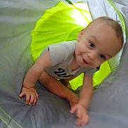 Joseph is registered to the contest to win money with this photo: baby, child, infant, crawling, smiling, happy, portrait, face, hands, arms, indoor, play_tent, fabric, green, gray, clothing, curious, sitting, photography, home