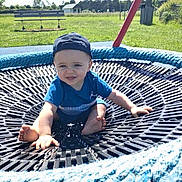 Lino a rejoint le concours — aidez-le/la à gagner de superbes lots ! bench, blue_clothing, cap, child, daylight, footwearless, grass, happy, nature, outdoor, park, person, playground, recreation, rope, seat, smiling, sunny, swing, toddler