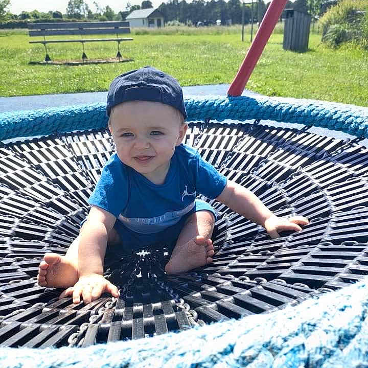 Lino a rejoint le concours — aidez-le/la à gagner de superbes lots ! bench, blue_clothing, cap, child, daylight, footwearless, grass, happy, nature, outdoor, park, person, playground, recreation, rope, seat, smiling, sunny, swing, toddler