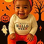 baby, child, smile, halloween, orange, black, headband, pumpkin, ghost, bat, tree, cross, socks, curly_hair, long_sleeve_shirt, pants, holiday, festive, costume, portrait