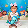 Journi Reign is registered to the contest to win money with this photo: baby, child, pink_bow, plush_toy, mermaid, cartoon_background, underwater_theme, happy, smiling, sitting, white_rug, cute, indoor, portrait, infant, toy, colorful, playful, decor, young_child