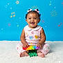 Journi Reign joined the competition — help win amazing prizes! baby, child, smiling, sitting, toy, rainbow, colorful, pink_bows, curly_hair, blue_background, musical_notes, stars, smiling_sun, carpet, cute, happy, playful, clothing, infant, portrait