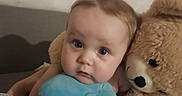 Ace joined the competition — help win amazing prizes! baby, child, teddy_bear, plush_toy, blue_pillow, heart_shaped_pillow, blanket, couch, indoor, cute, infant, soft_toys, portrait, face, looking_at_camera, cozy, resting, comfort, young_child, furniture