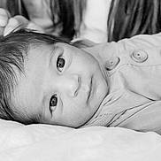 Giovanni is registered to the contest to win money with this photo: baby, black_and_white, button, calm, close_up, clothing, cute, eyes, face, hair, hand, infant, lying_down, newborn, person, portrait, resting, skin, soft, young_child