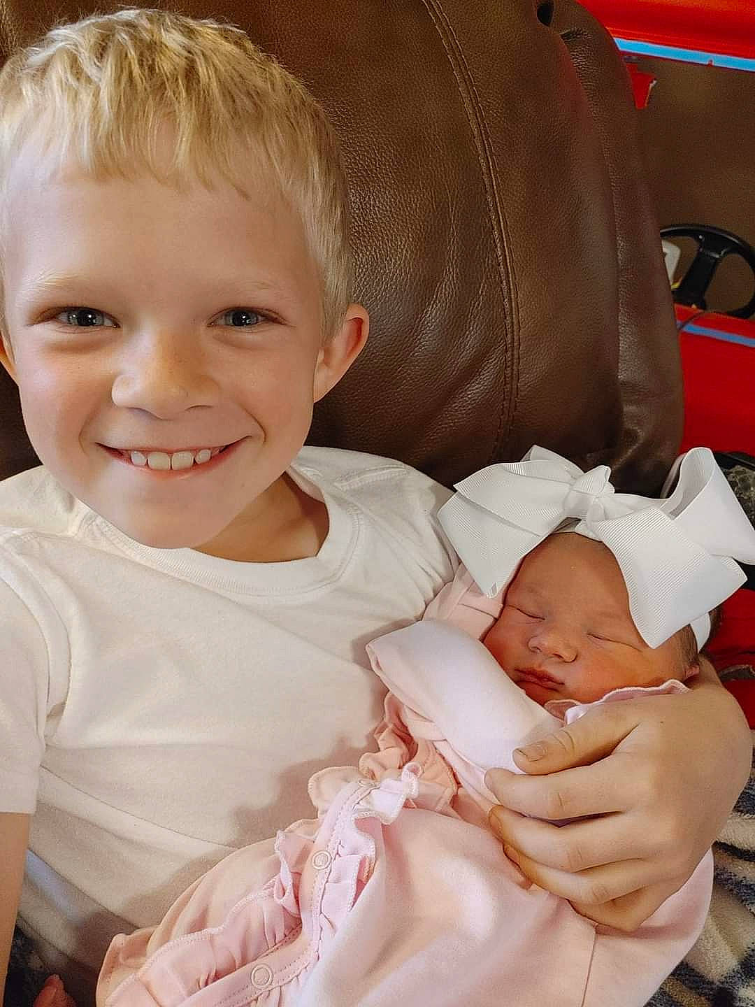 Mallorie is registered to the contest to win money with this photo: baby, baby_products, baby_toddler_clothing, cheek, child, chin, comfort, eye, facial_expression, gesture, happy, human_body, joy, mouth, person, sitting, skin, sleeve, smile, thumb