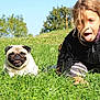 child, dog, pug, grass, outdoor, playful, tongue_out, sunny, happy, nature, casual_clothing, greenery, fun, young, animal, pet, portrait, summer, field, smiling