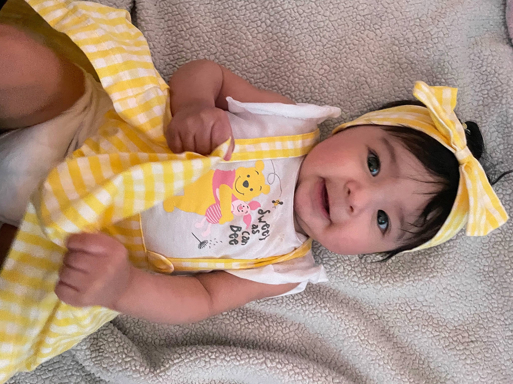 Lilly is registered to the contest to win money with this photo: arm, baby, baby_toddler_clothing, cheek, child, comfort, eye, face, finger, hand, head, headwear, human_body, lip, nose, person, product, skin, sleeve, smile