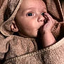 baby, infant, towel, thumb_sucking, wrapped, cozy, soft_texture, face, skin, hand, eyes, curious, cute, child, portrait, indoors, fabric, blanket, newborn, warm