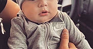 Imran joined the competition — help win amazing prizes! adult, baby, beanie, car, car_seat, child, close_up, face, fashion, gray_clothing, hand, indoor, infant, looking_at_camera, portrait, safe, sitting, tracksuit, vehicle, wide_eyes