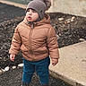 beanie, boots, child, driveway, garden, house, jacket, outdoor, pants, photography, pom_pom, portrait, puffer_coat, serious_expression, sidewalk, standing, stone, toddler, winter, winter_clothing