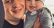 Imran is registered to the contest to win money with this photo: adult, baby, beanie, child, close_up, faces, family, father, gray_clothing, happy, holding, indoor, man, nike, parent, photography, portrait, selfie, smiling, winter_clothing