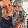 adult, baby, beanie, child, close_up, faces, family, father, gray_clothing, happy, holding, indoor, man, nike, parent, photography, portrait, selfie, smiling, winter_clothing
