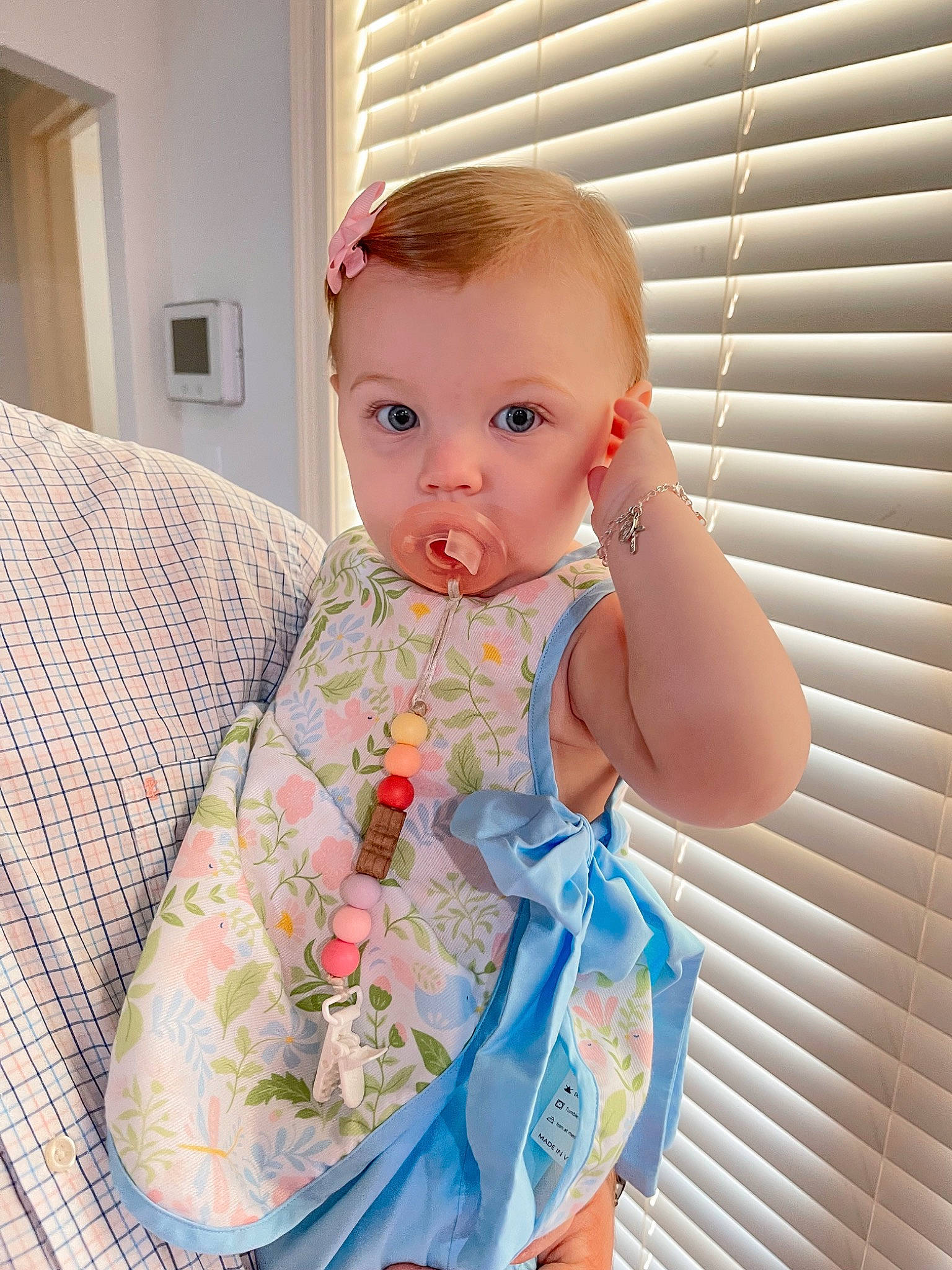 Emery is registered to the contest to win money with this photo: baby, baby_products, baby_toddler_clothing, cheek, child, day_dress, dress, eye, fashion_design, head, linens, neck, one_piece_garment, pattern, peach, person, sitting, skin, sleeve, toddler