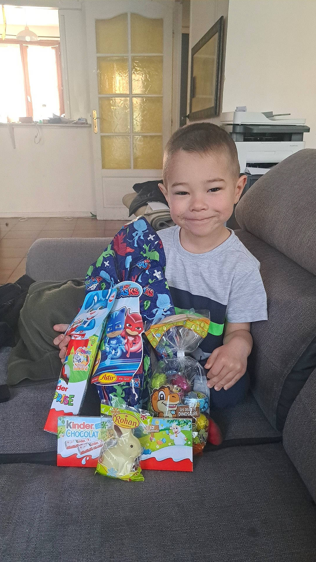 Liam participe au concours pour gagner de l'argent avec cette photo : child, christmas, comfort, couch, curtain, event, flooring, fun, holiday, joy, lap, living_room, person, play, present, room, sitting, smile, t_shirt, toddler