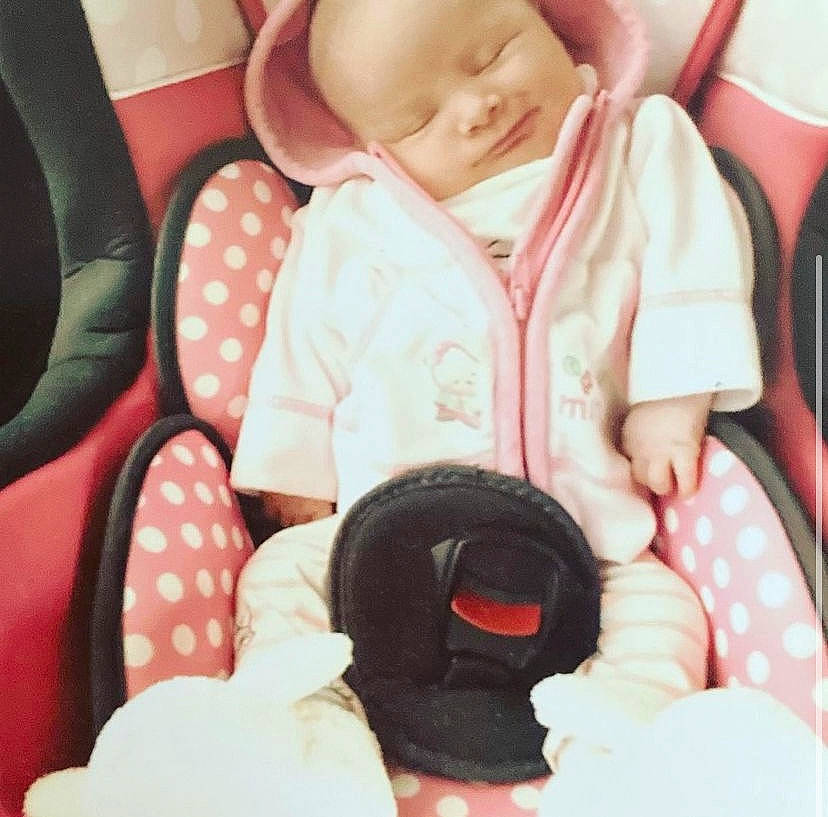 Kenza a rejoint le concours — aidez-le/la à gagner de superbes lots ! baby, baby_toddler_clothing, beauty, child, comfort, facial_expression, finger, happy, linens, nail, outerwear, pattern, people, person, pink, sitting, sleeve, t_shirt, thumb, toddler