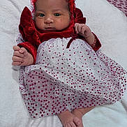 Ashley is registered to the contest to win money with this photo: baby, infant, dress, red, white, polka_dot, headband, blanket, feet, hands, face, portrait, cute, newborn, sleepwear, lying_down, indoor, soft_texture, fabric, child
