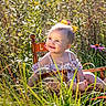baby, child, toddler, smiling, portrait, outdoor, garden, nature, flowers, purple_flower, grass, foliage, wooden_chair, sundress, yellow_bow, sitting, sunlight, happy, playful, photography