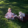 baby, child, infant, outdoor, grass, meadow, sunlight, portrait, sitting, romper, hair_bow, smiling, face, plush_toy, elephant, stuffed_animal, suitcase, blanket, nature, photography