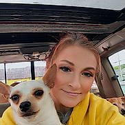 Lottie is registered to the contest to win money with this photo: animal, car_interior, casual, companion, cute, dog, friendly, happy, harness, indoor, pet, portrait, seat, selfie, small_dog, smile, sunroof, window, woman, yellow_hoodie