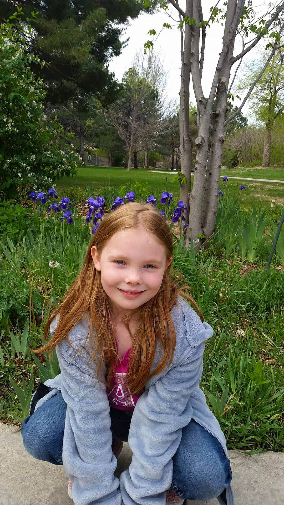 Kennedy is registered to the contest to win money with this photo: botany, brown_hair, electric_blue, fashion_accessory, fun, garden, grass, grassland, happy, iris, joy, leisure, long_hair, people_in_nature, person, plant, recreation, sitting, sky, smile