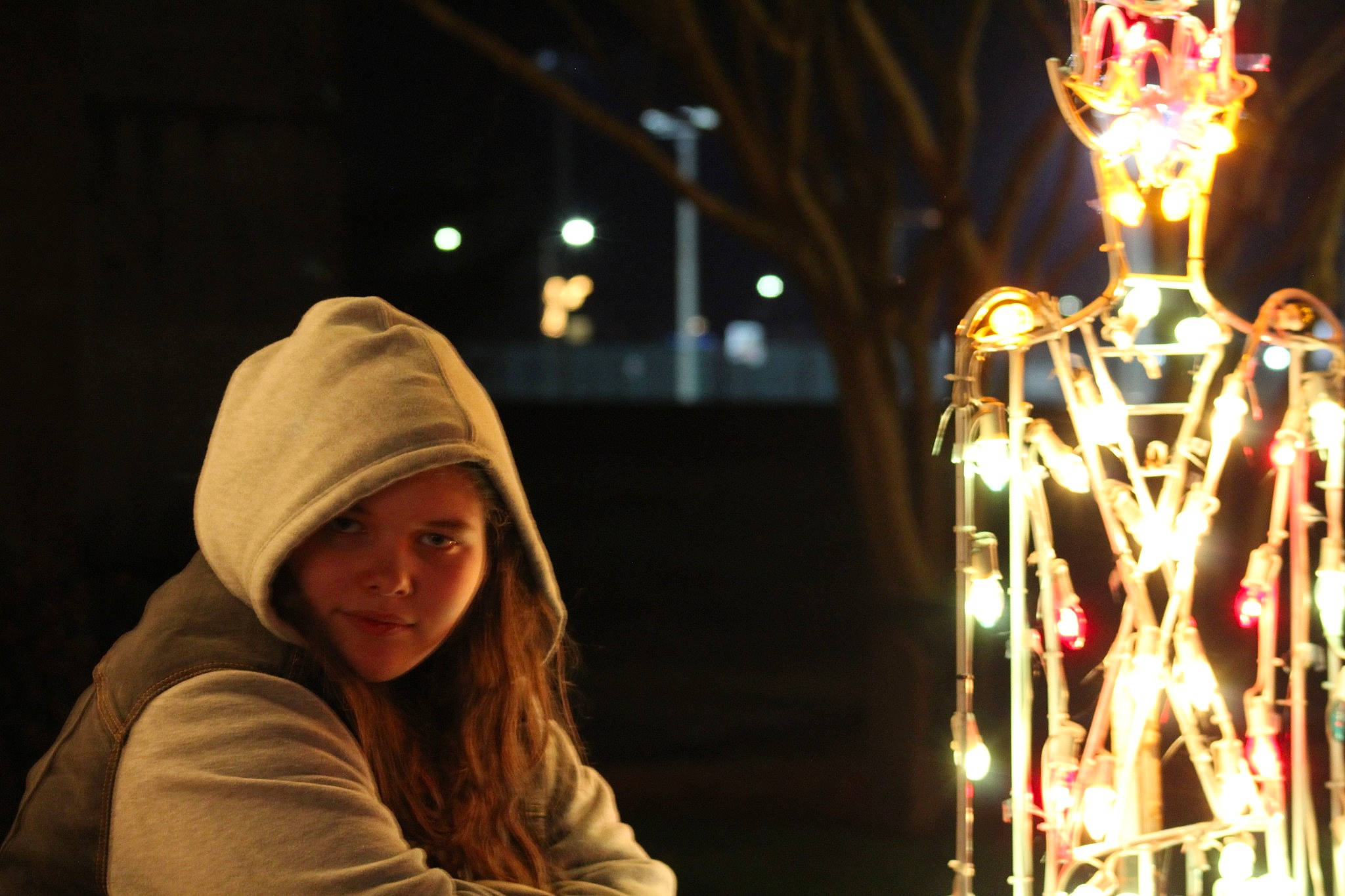 Sylvia is registered to the contest to win money with this photo: beanie, cap, city, darkness, event, fun, glass, headwear, heat, human_body, knit_cap, leisure, light, light_fixture, lighting, metal, night, person, sitting, smile
