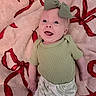 Scottie joined the competition — help win amazing prizes! baby, child, smiling, green_bow, green_shirt, patterned_pants, blanket, red_ribbons, soft_texture, happy, cute, infant, lying_down, indoors, portrait, young_child, headband, clothing, person, face