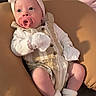 Scottie joined the competition — help win amazing prizes! baby, infant, pacifier, headband, bow, cushion, clothing, socks, mittens, face, person, indoor, seated, cute, soft_lighting, blanket, comfort, portrait, young_child, relaxing