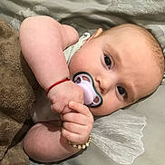 Dolly joined the competition — help win amazing prizes! baby, pacifier, blanket, pillow, infant, sleeping, hand, face, skin, cute, child, lying_down, resting, cozy, comfort, wearing_bracelet, indoor, closeup, young, peaceful