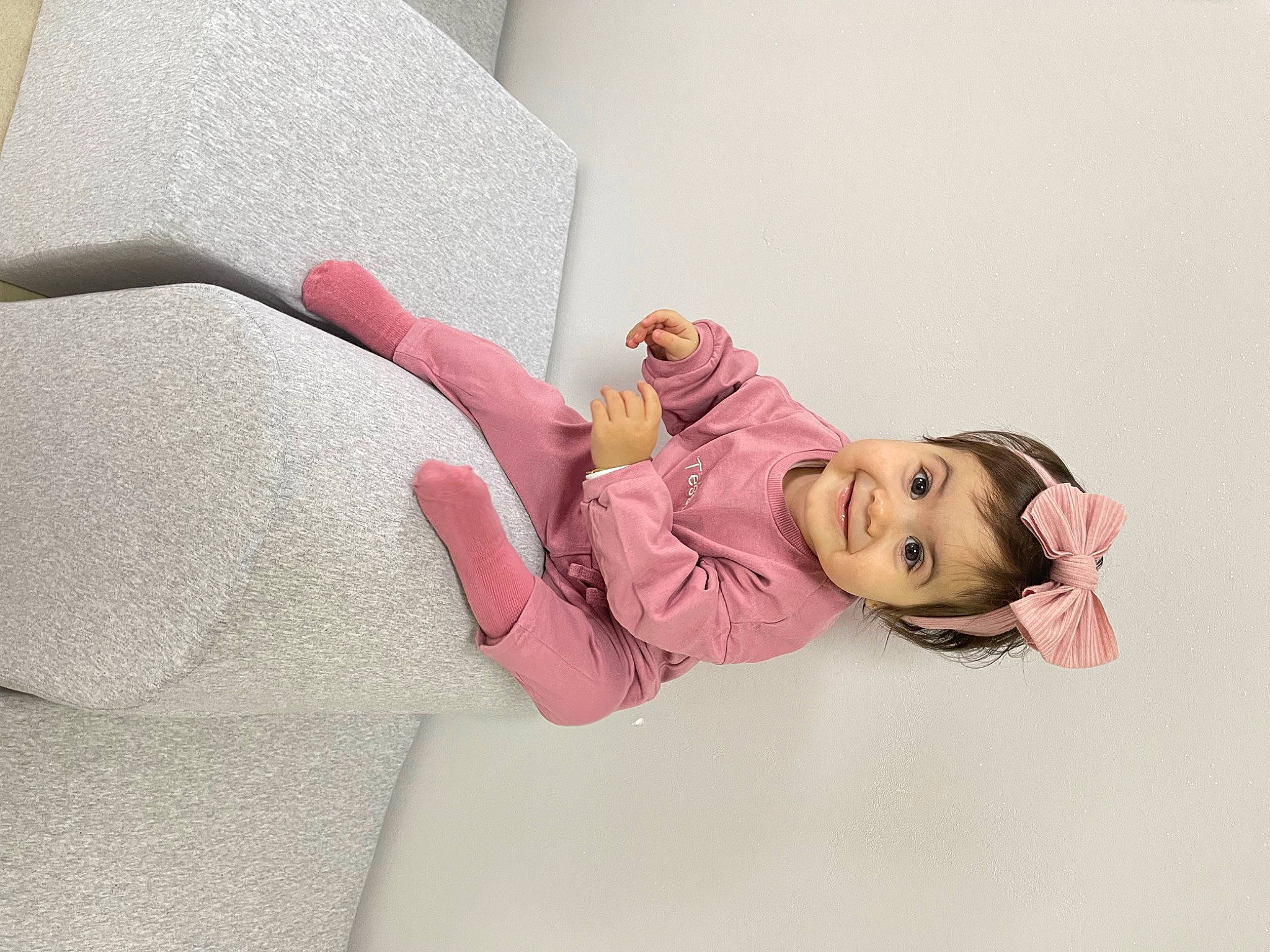 Tessia participe au concours pour gagner de l'argent avec cette photo : arm, baby_toddler_clothing, child, comfort, elbow, eyelash, fashion_accessory, finger, gesture, hand, happy, human_leg, joy, linens, magenta, neck, person, pink, sleeve, textile