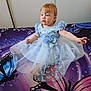 Elysianna participe au concours pour gagner de l'argent avec cette photo : toddler, child, blue_dress, butterfly_pattern, flower_detail, bedspread, butterfly, indoor, curly_hair, light_skin, sitting, portrait, cute, baby, clothing, fabric, soft_lighting, expression, room, casual