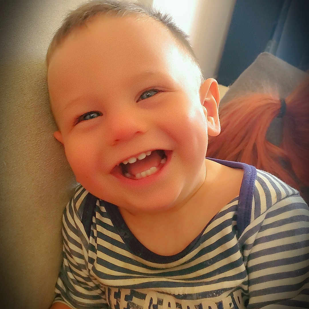 Christopher a rejoint le concours — aidez-le/la à gagner de superbes lots ! blue_eyes, casual, child, clothing, couch, cute, face, hair, happy, indoor, joy, light, person, portrait, sitting, smiling, striped_shirt, teeth, toddler, young_child