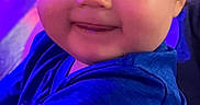 Timothy joined the competition — help win amazing prizes! adult_hands, baby, being_held, blue_lighting, blue_shirt, cheeks, child, close_up, clothing, colorful_lighting, curly_hair, eyes, face, happy, indoor, infant, photography, portrait, purple_lighting, smiling