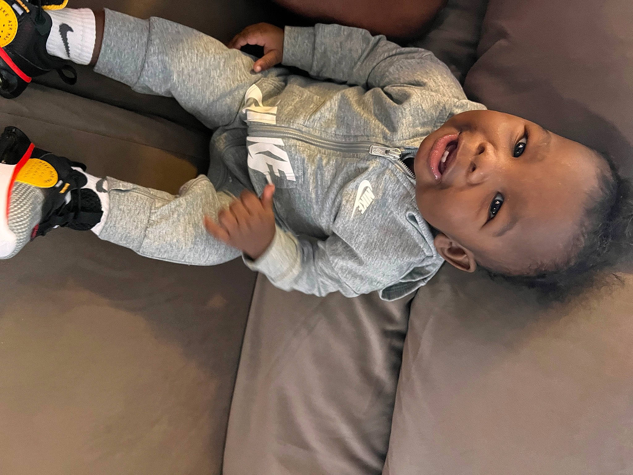 Dion is registered to the contest to win money with this photo: baby, carmine, child, comfort, elbow, flash_photography, fun, glove, happy, hat, human_leg, knee, person, portrait_photography, smile, sock, sports_gear, thigh, toddler, tree