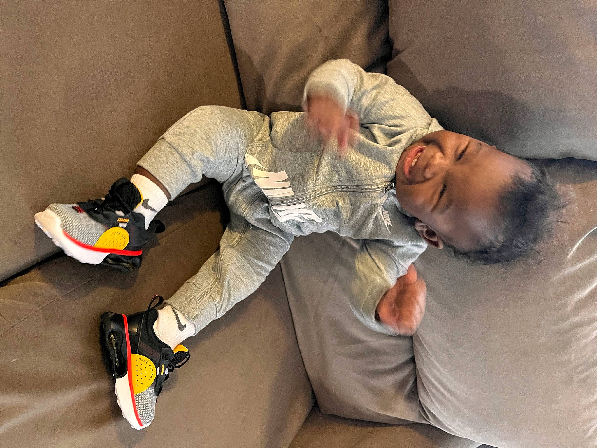 Dion is registered to the contest to win money with this photo: athletic_shoe, carmine, comfort, elbow, eyewear, flooring, fun, human_leg, joint, joy, knee, leg, outdoor_shoe, person, room, shoe, sitting, sneakers, sportswear, thigh