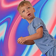 Azari is registered to the contest to win money with this photo: abstract_background, blue_clothing, blue_shirt, boy, child, closeup, colorful_background, facial_expression, leaning, looking_up, neon_colors, open_mouth, outdoor_style, person, photography, portrait, short_hair, standing, swirling_pattern, vibrant