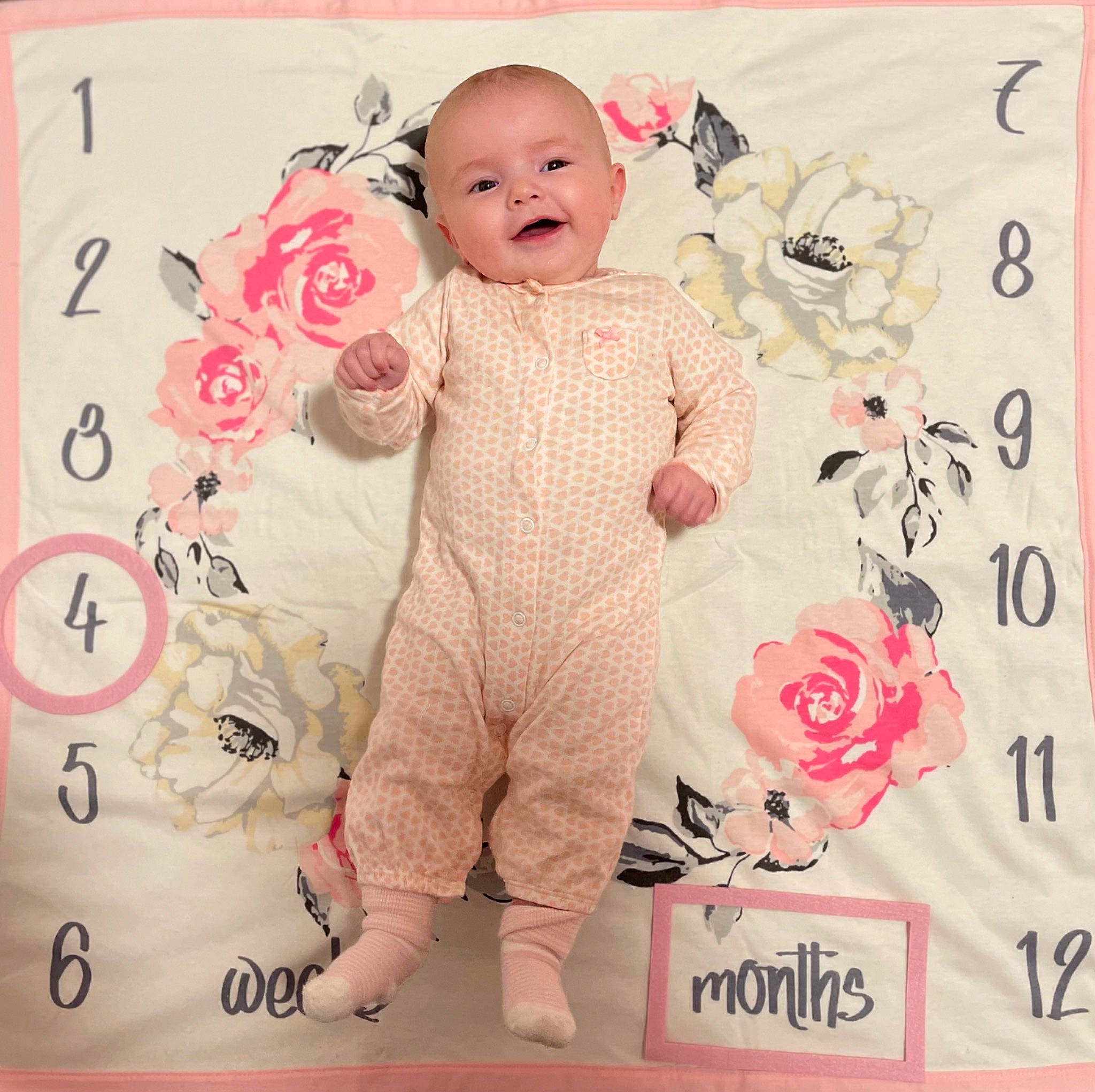 Ellie is registered to the contest to win money with this photo: baby, baby_toddler_clothing, cheek, child, facial_expression, font, happy, linens, magenta, material_property, pattern, peach, person, pink, skin, sleeve, smile, t_shirt, textile, toddler