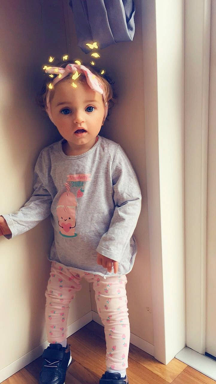 Eden participe au concours pour gagner de l'argent avec cette photo : baby, baby_toddler_clothing, brown_hair, cheek, child, child_model, doll, ear, face, hair_accessory, head, person, pink, skin, sleeve, standing, surprise, toddler, toy
