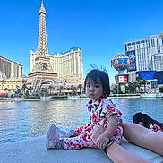 Gracie joined the competition — help win amazing prizes! architecture, building, child, city, cityscape, clothing, face, female, footwear, girl, head, metropolis, outdoors, person, photography, portrait, shoe, urban, water, waterfront