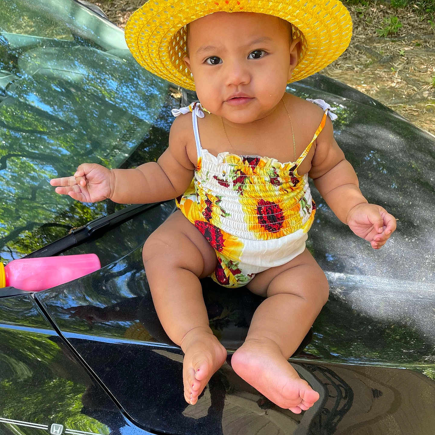 Alani Hazel is registered to the contest to win money with this photo: baby, bodypart, clothing, dress, face, finger, grass, hand, hat, head, outdoors, person, photography, plant, portrait, sitting, summer, sunhat, swimwear, transportation