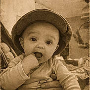 Léo participe au concours pour gagner de l'argent avec cette photo : baby, child, hat, hand, fingers, adult_hand, vintage, sepia, portrait, indoors, cute, infant, clothing, plaid, expression, face, person, sitting, warm_tone, grip