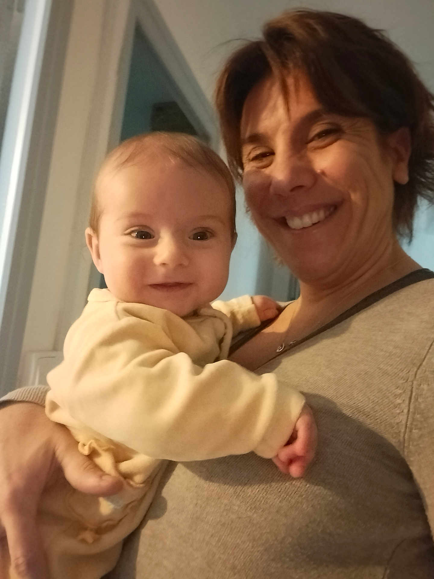 Ethan participe au concours pour gagner de l'argent avec cette photo : baby, woman, smiling, happy, indoor, person, child, holding, face, portrait, family, love, affection, clothing, sweater, skin, hand, head, hair, light