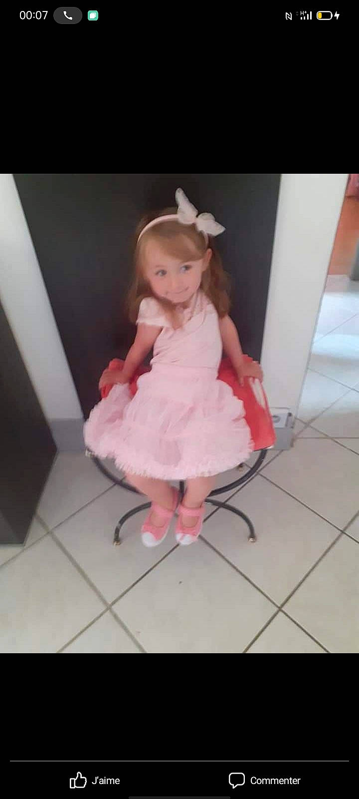 Cassidy a rejoint le concours — aidez-le/la à gagner de superbes lots ! baby_toddler_clothing, bridal_accessory, day_dress, dress, embellishment, fashion_accessory, fashion_design, floor, flooring, formal_wear, hand, happy, head, human_leg, long_hair, one_piece_garment, person, pink, ruffle, sleeve