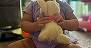 Kiara is registered to the contest to win money with this photo: baby, bunny, carpet, child, closeup, facial_expression, hands, home, indoors, natural_light, onesie, open_mouth, playroom, plush_toy, portrait, purple_clothing, sitting, stuffed_animal, toddler, toy