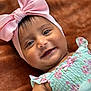 baby, child, infant, smile, face, headband, pink_bow, blue_eyes, dress, floral_pattern, pastel_colors, cute, lying_down, soft_blanket, close_up, portrait, happy, skin, person, adorable