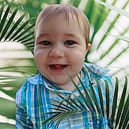 Maxime a rejoint le concours — aidez-le/la à gagner de superbes lots ! baby, child, smiling, face, portrait, plaid_shirt, blue, green, outdoor, nature, leaf, palm_leaf, happy, cute, young, person, toddler, closeup, eyes, expression