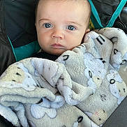 Jasper is registered to the contest to win money with this photo: baby, blanket, car_seat, child, face, blue_eyes, expression, fur_texture, infant, looking_at_camera, person, plush, seatbelt, soft, toddler, transportation, warm, wrapped, young, cute