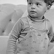 Ismael a rejoint le concours — aidez-le/la à gagner de superbes lots ! black_and_white, child, clothing, couch, curious, curly_hair, cute, eyes, face, furniture, hair, indoor, long_sleeve_shirt, overalls, person, portrait, soft_lighting, standing, toddler, young_child
